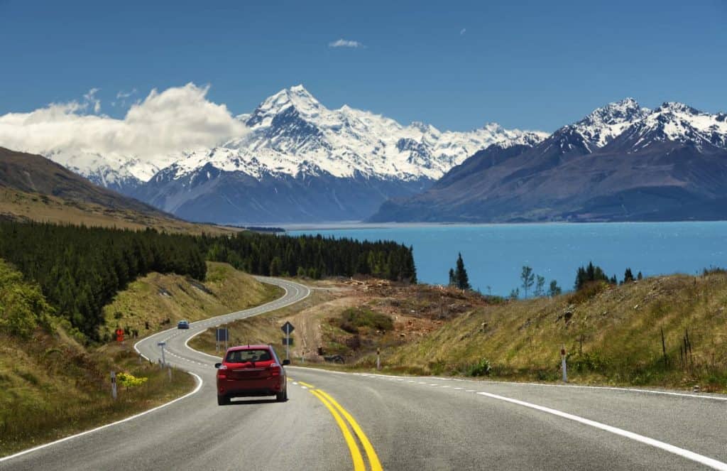 Auto op de weg met uitzicht op Mount Cook in Nieuw-Zeeland