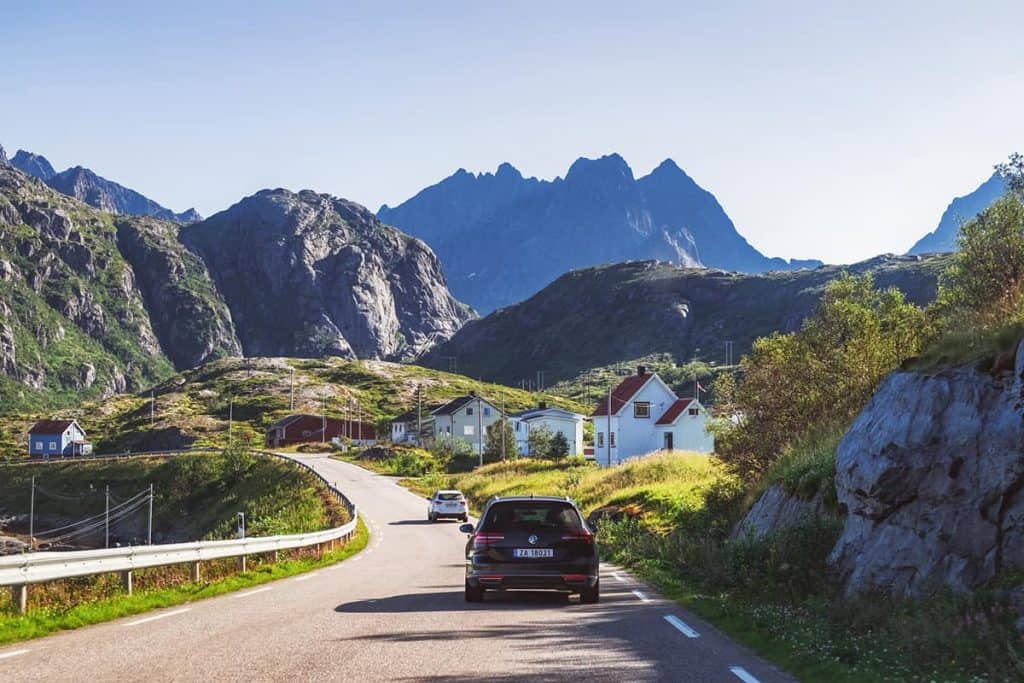 Autoweg in de Lofoten met witte huizen in Noorwegen