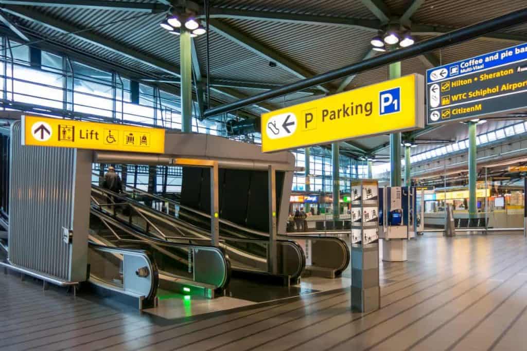 Ingang van Schiphol Amsterdam Airport met borden naar de parking