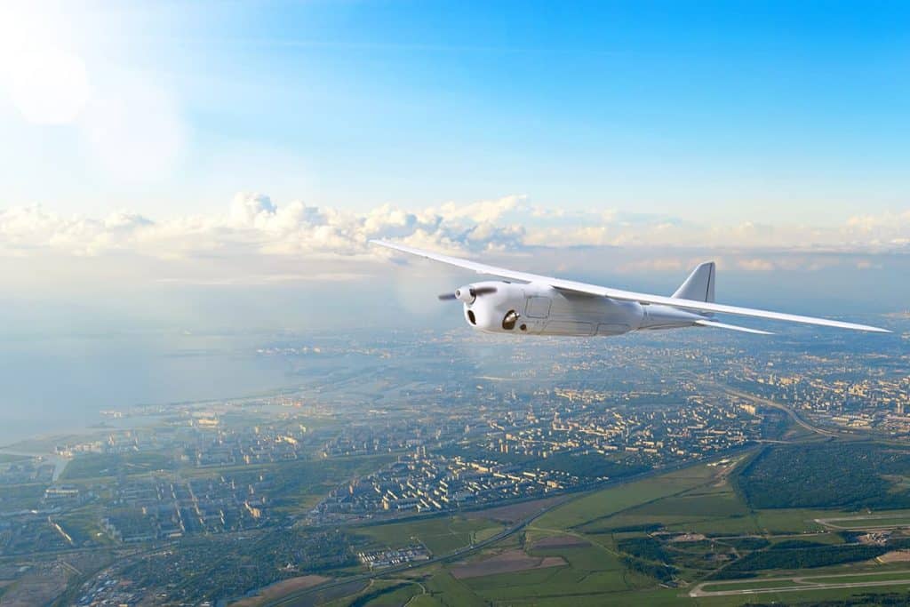 Onbemande witte drone vliegt rond boven stad