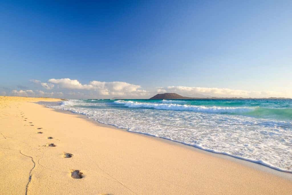 Strand met voetstappen en uitzicht op Lobos en Lanzarote op Fuerteventura