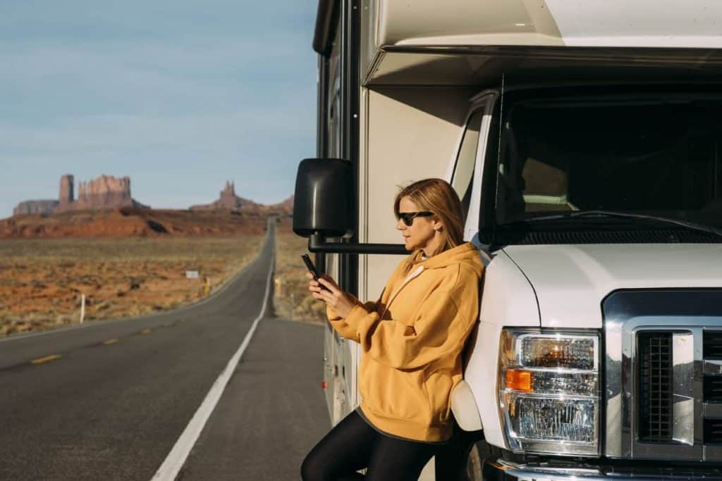 Vrouw op telefoon bij een camper in Monument Valley, USA