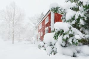 Rood houten huis in Zweden met heel veel sneeuw
