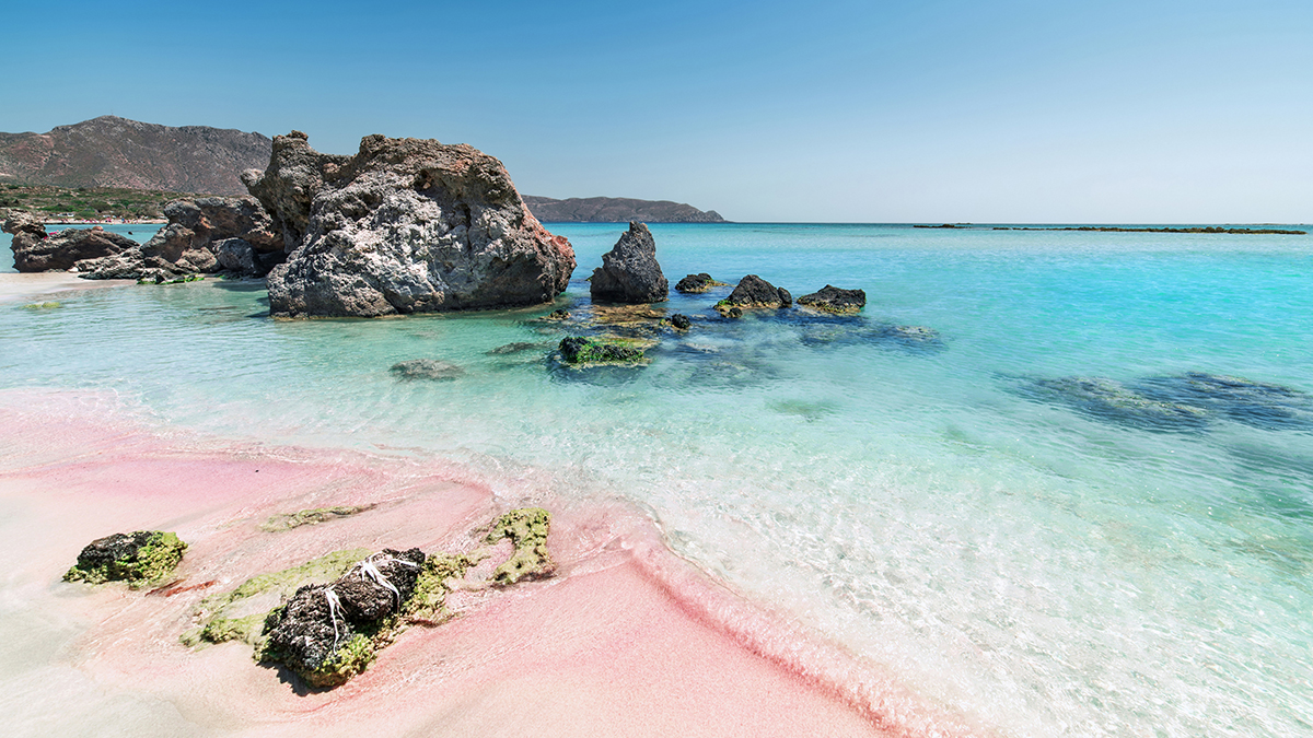 Blauwe zee en roze strandzand van Elafonisi op Kreta