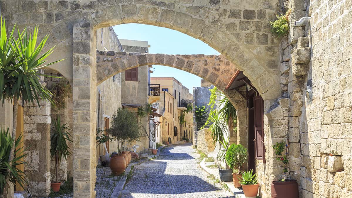 Oude straat met vestingmuur en bloemen in Rhodos-stad op Rhodos